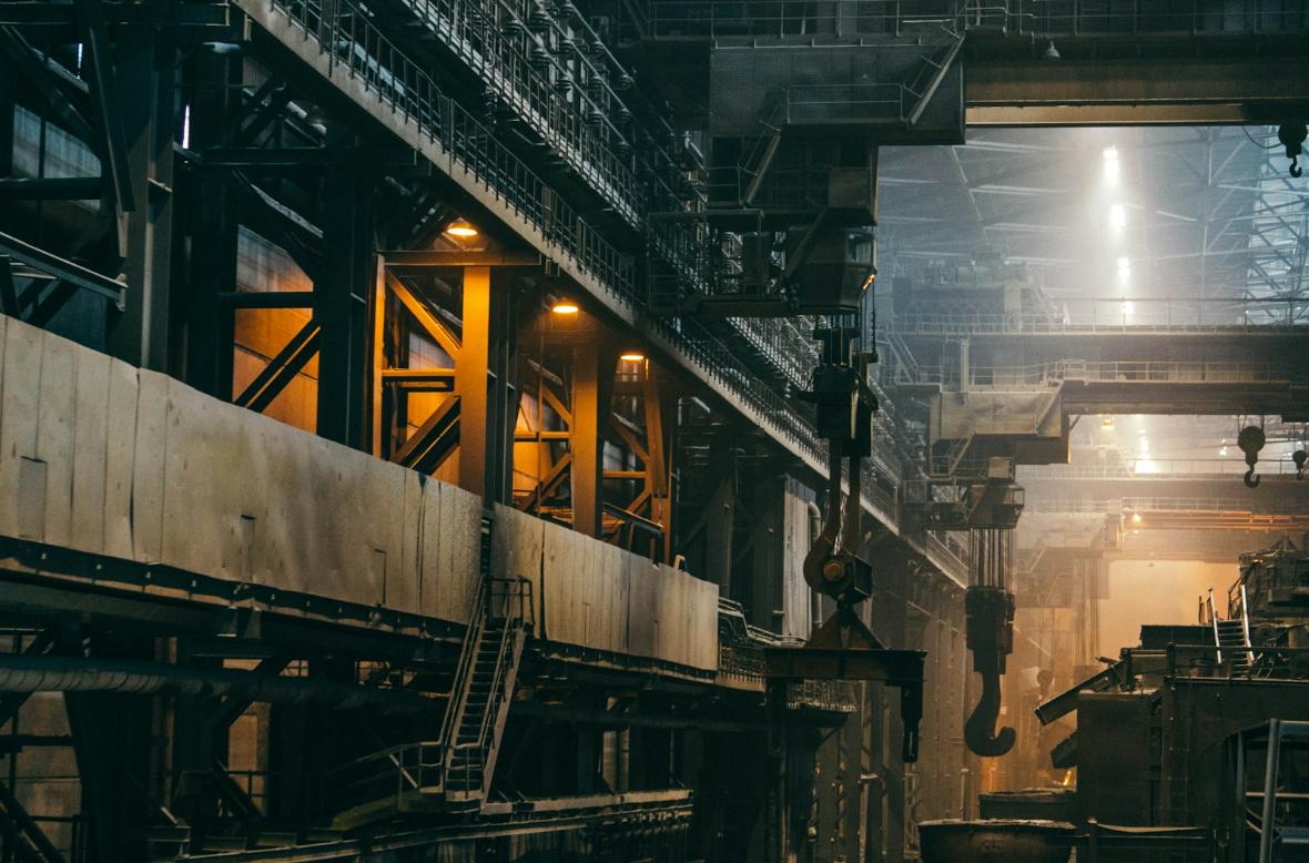 Interior de planta industrial com pontes rolantes e estrutura metálica em operação